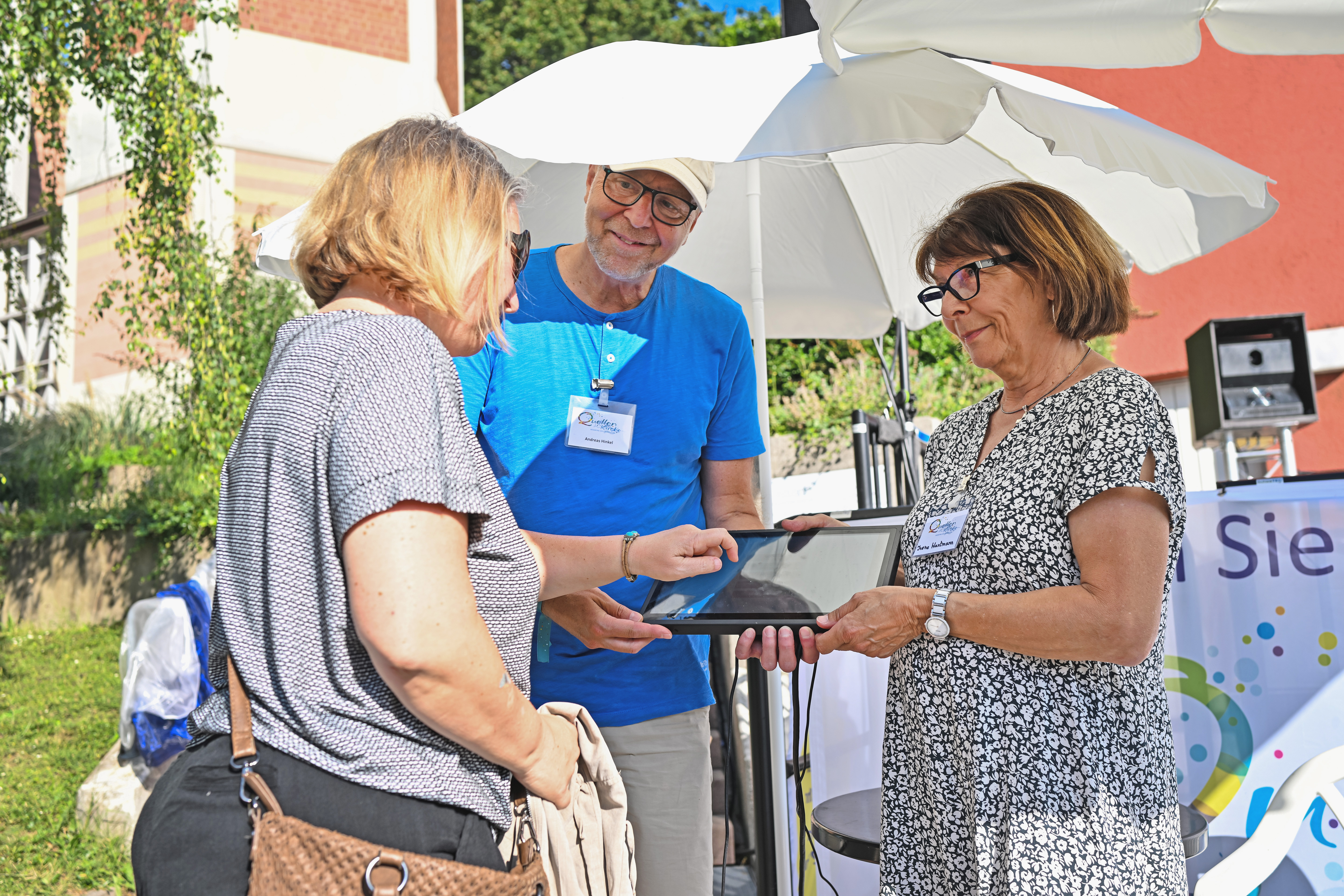 Helfer:innen auf dem Hessentag im Gespräch mit Besucher:innen.