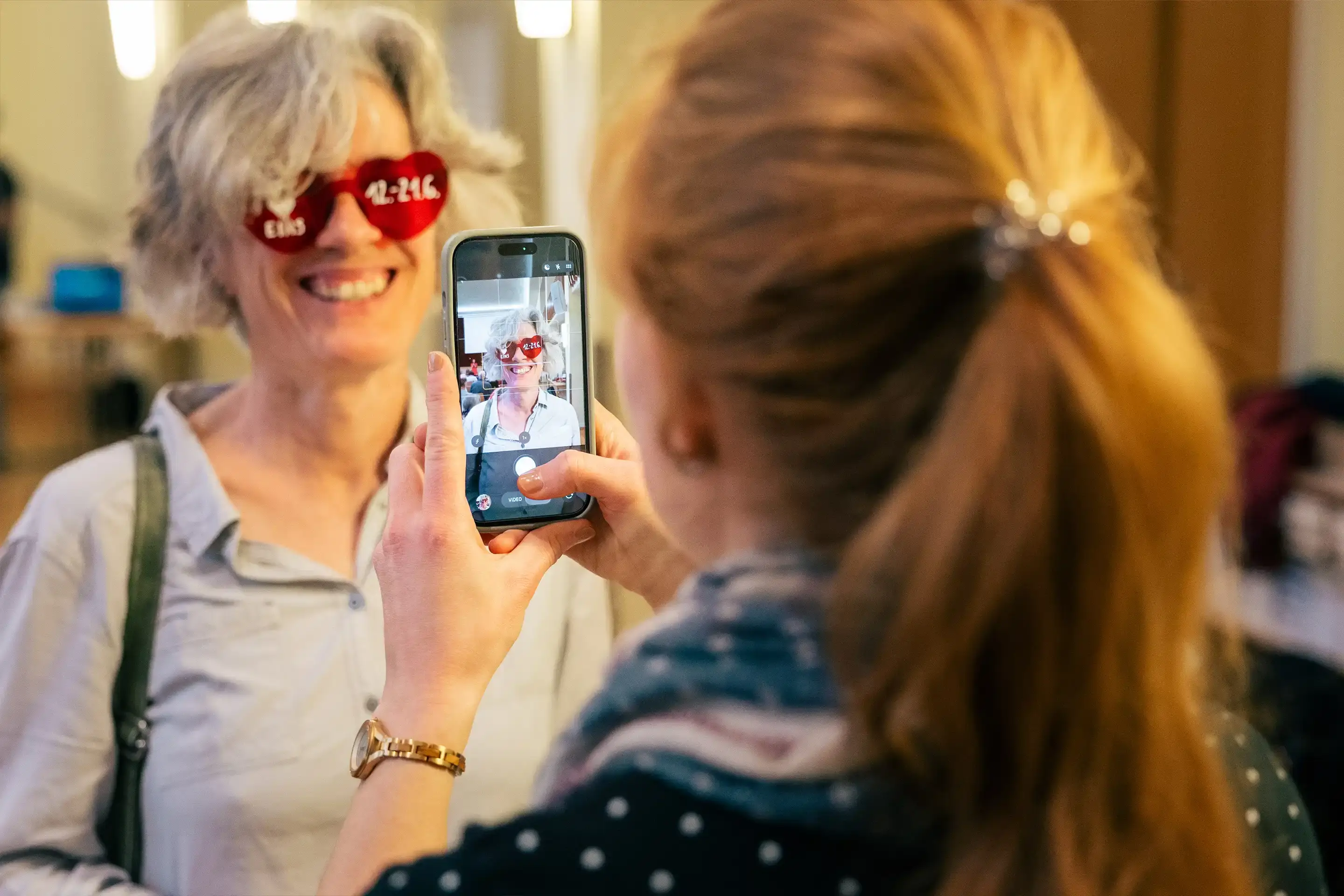 Helfer machen ein Foto mit einer lustigen Brille während einer Ehrenamtsschulung. Hierauf ist das Datum des diesjährigen Hessentagsauftritts zu lesen.